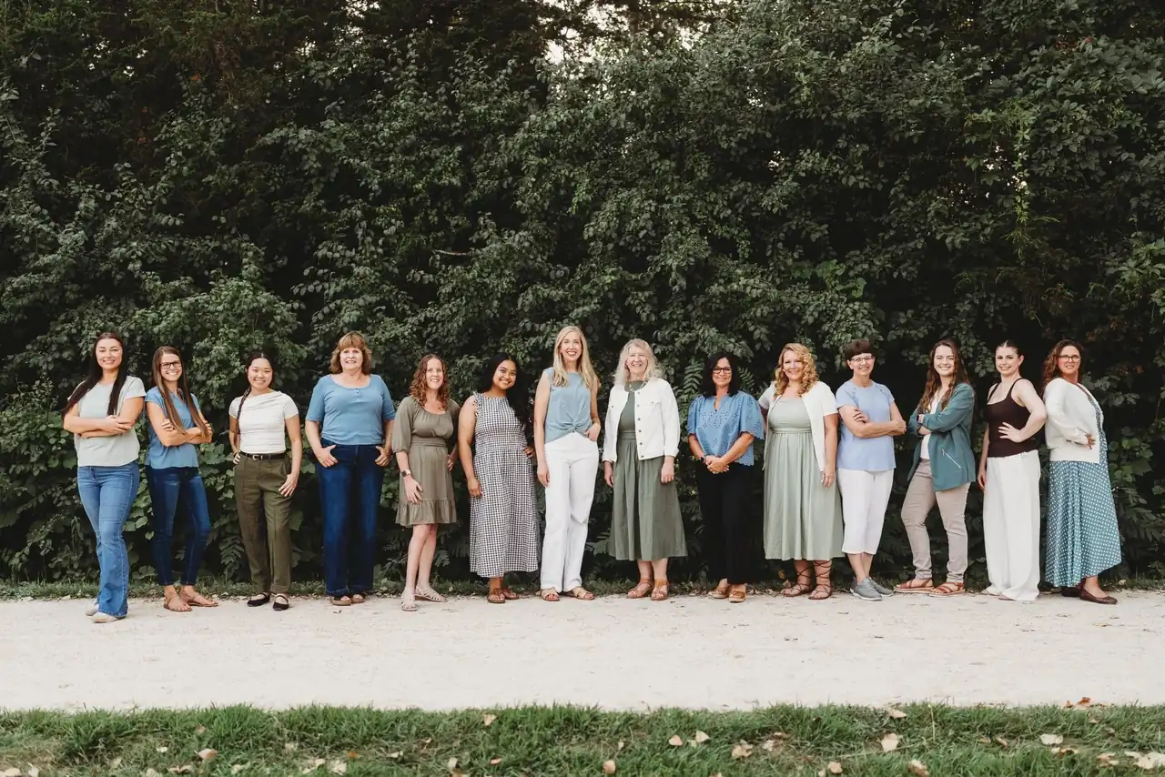The Tonka Smiles team standing together outdoors in front of green trees.