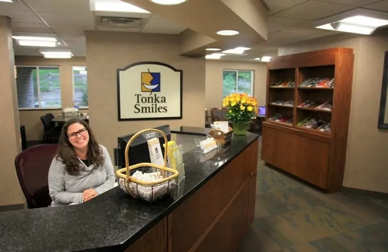 The Tonka Smiles front desk, with a basket on the counter and the practice's sign behind it.
